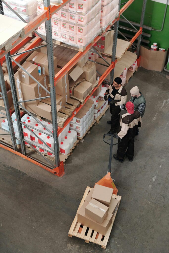 Three warehouse workers discussing inventory organization details.